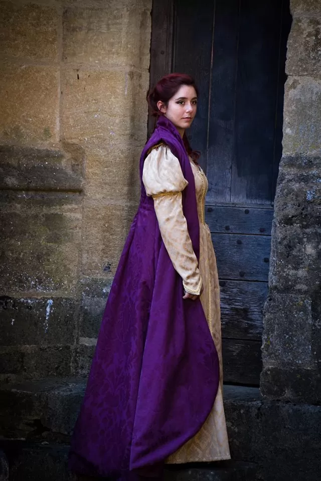 Vue de côté, robe dorée et manteau à grand col et épaulettes