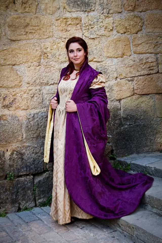 Vue de face, robe dorée et manteau à grand col et épaulettes