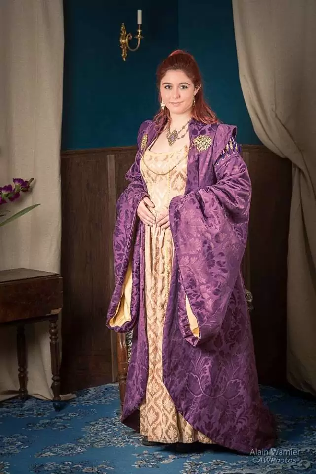 Vue de face, robe dorée et manteau à grand col et épaulettes, décor historique